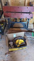 Full view of folding work bench and circular saw in a box on the floor below it.