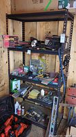 Metal shelf frame with wood shelf inserts seen in shed with various tools on it (not included).