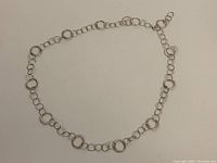 Full view of the 36 inch silver hoop necklace showing the chain of hoops and links.