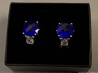 Front view of blue and clear cubic zirconia earrings in black box
