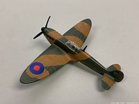 Top-front angle view of the Dinky Toys Spitfire MKII die-cast model plane showing camouflage paint and roundel decal on right wing.