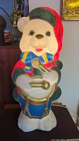 Front view of the 32 inch blown mold bear holding a drum, showing colorful painted details and facial expression.