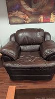 Front view of the brown leather armchair showing padded cushions and leather upholstery