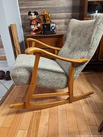 Right side profile showing curved rocker base, armrest shape, upholstery condition