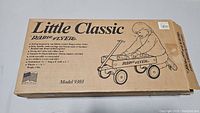 Photo of the front of the original box of the Little Classic Radio Flyer Model 9303 ride-on wagon with product illustration and description.