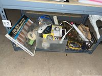 Photo of shelf with various tools, tapes, brushes in containers and baskets
