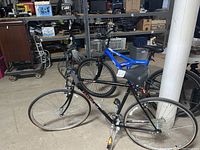Side view of both bicycles inside a storage room showing the Univega road bike in front and the Kent mountain bike behind