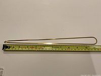 Chain laid flat next to measuring tape showing 23-inch length