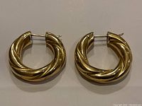 Pair of twisted hoop earrings front view on flat surface