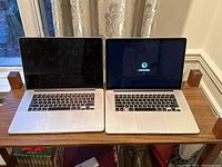 Two MacBook Pro 15" Retina laptops side by side, left unit off, right unit showing internet recovery prompt