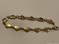 Bracelet laid flat showing heart link design and clasp.