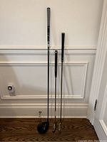 Three clubs upright against wall