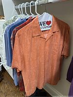 Orange tonal botanical silk shirt at front of row