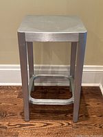Front view of aluminium counter stool showing seat, legs, and footrest