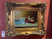 Full view of oil painting within ornate gilt frame against wall