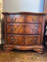 Full front view of the dresser showing three drawers, serpentine front and bracket feet