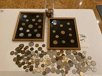 Overall view of two framed displays, loose coins spread out and glass jar of coins