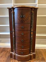 Front view of entire chest showing drawers, side doors, painted columns.