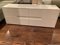 Front view of white lacquered console showing four drawers and overall condition