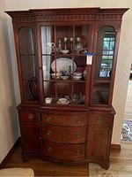 Front view of antique mahogany china hutch with glass upper cabinet and bottom drawers and doors, showcasing original Hepplewhite brass pulls and knobs.