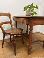 Desk and chair set showing desk side angled with drawer and chair next to it on wood flooring