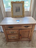 Front view of antique dry sink dresser with drawers and cabinet with framed painting placed on top.