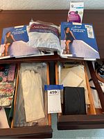 Drawer with Hanes Silky Sheer pantyhose packages, white gloves, black purse, and dark brown belt.