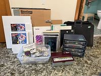 Front view of storage bin with paint tubes, plastic organizer, metal paint tin and black carrying case