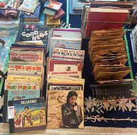 Photo showing mixed LP records in containers including some 78 rpm records and colorful album covers with one album showing the Beatles and Walt Disney's Mary Poppins soundtrack.