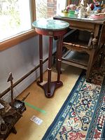 Full view of the wooden occasional table with removable round green marble top placed near window, showing side and base.