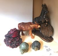 Lot view showing wood horse holding round sign marked Philippines, wood water buffalo, Feng Shui red money frog on coins, and two green carved stone turtles.