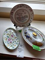 Full view of all three china pieces: Villeroy & Boch plate on black stand, Minton Evesham covered vegetable dish with fruit design, and Minton floral tray.