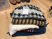 Stack of five scarves showing different textures and colors, includes tag marked 100% Baby Alpaca.