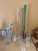 Set of six glass vases arranged on a surface.