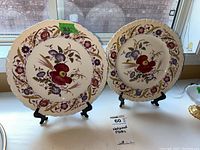 Pair of Wedgwood 'Cornflower' decorative plates on black stands, showing floral patterns and scalloped edges.