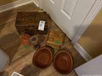 Full overview photo showing the large carved wooden box, small carved wooden box, two wooden bowls, small wooden sculpture, and terracotta trinket box grouped together