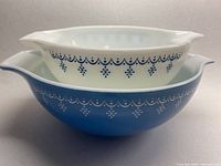 Two Pyrex nesting bowls stacked, larger blue bowl on bottom and smaller white bowl inside