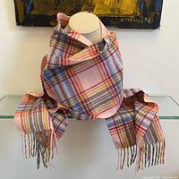 Scarf displayed wrapped on a mannequin. Shows full length and fringe ends.
