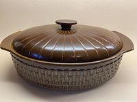 Front profile view of the Wedgwood Pennine lidded casserole dish showing lid with linear indented radiating details and cinnamon textured body.