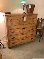 Full front view of rustic wooden dresser with five drawers and drop-front desk section, metal hardware, natural wood finish.