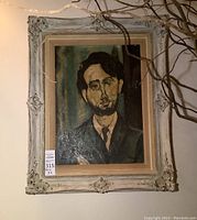 Full view of framed portrait painting of a bearded man wearing suit and tie