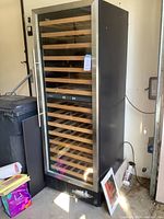 Full view of black stainless steel wine refrigerator with glass door and wooden shelves