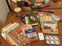 Wide photo showing antique wooden trains, plush dog, vintage books, and magazines on carpet