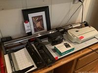 Wide view of all items showing painting, paper cutter, shredder, sharpener, hole punches, and radio