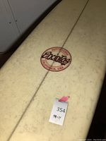 Top deck close-up showing embossed oval logo and center stringer with 94×24 dimension tag