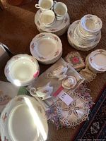Full overview of the Homer Laughlin china set showing various stacked plates, bowls, cups, and serving pieces with floral pattern