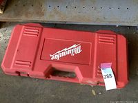 Closed red hard case with Milwaukee logo and lot number tag.