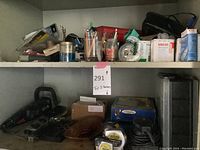 Top shelf showing various small hand tools, containers, and organized items including a box of bandages and a nail organizer