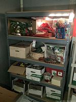 Full view of the metal utility shelving unit filled with various storage boxes and holiday decorations (not included).