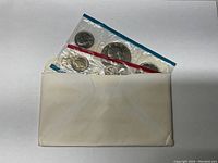 Two 1977 uncirculated U.S. Mint coin sets safely preserved in original plastic packaging inside original white envelope.